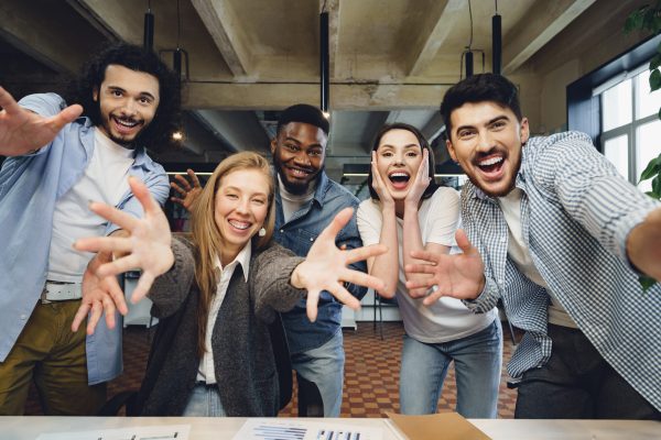 Happy overjoyed business team celebrate corporate victory in their office